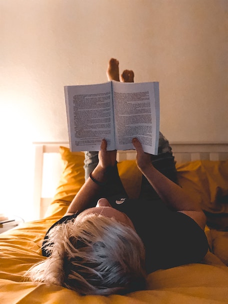 person reading a book in bed
